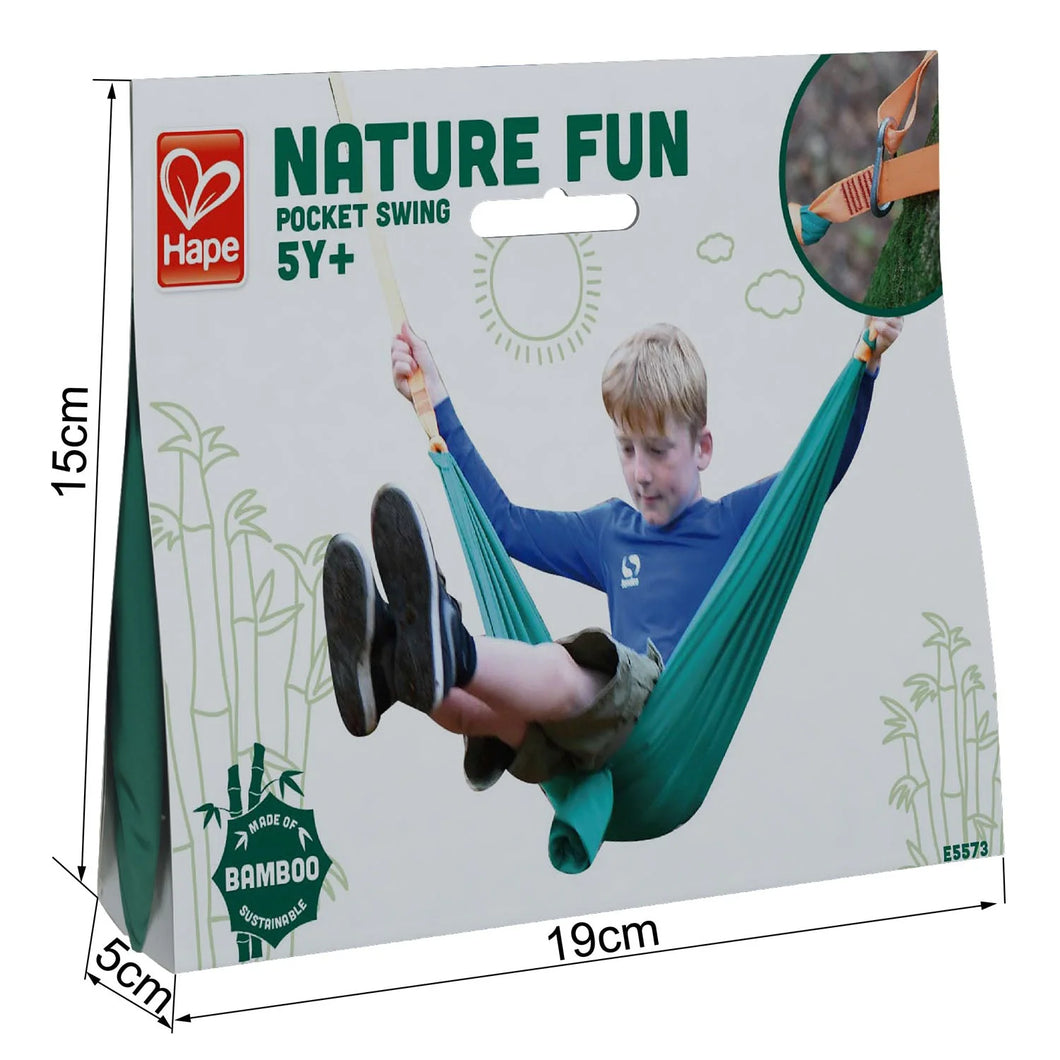 Hape bamboo made green and yellow Nature Fun Pocket Hammock Swing with young boy in blue swinging on hammock photo and clip photo on the 15 cm H x 19 cm W x 5 cm D white packaging with green text and graphics against white background.